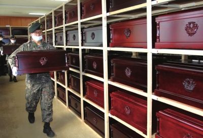 3月27日，韓國坡州市志愿軍遺骸臨時(shí)安置所，韓國士兵將棺槨起運(yùn)裝車。新華社發(fā)