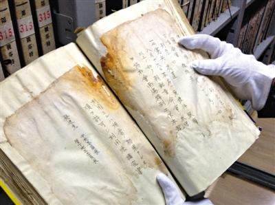　4月30日，吉林省檔案館庫(kù)房?jī)?nèi)，趙玉潔展示一冊(cè)檔案，庫(kù)房?jī)?nèi)恒溫恒濕，每天都會(huì)有例行的安全檢查。新京報(bào)記者 盧美慧 攝