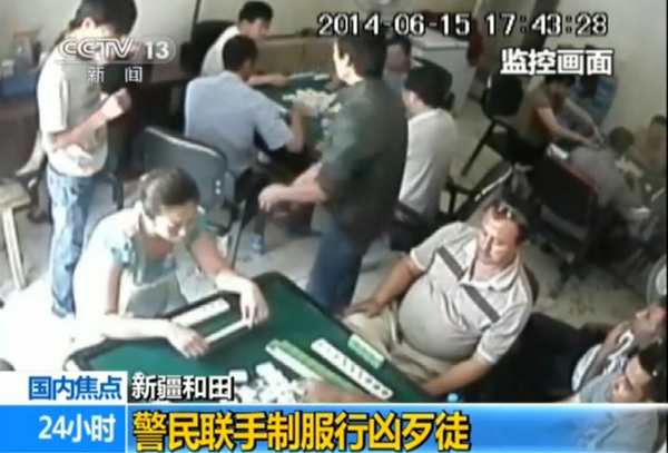 綠衣男子掏出斧頭砍向牌客，此時，白衣男子扔若無其事。