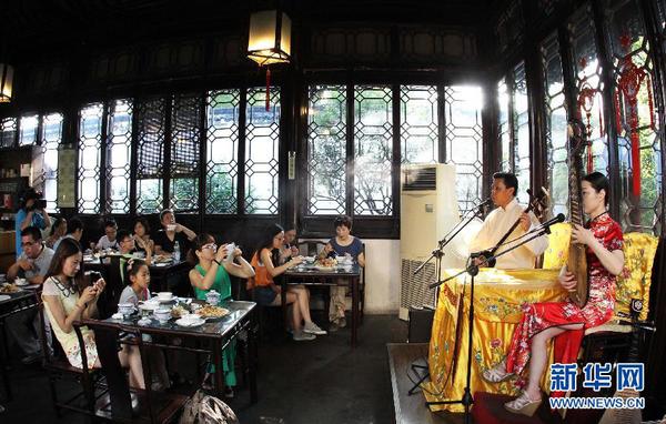7月20日早晨，游客在參加蘇州拙政園“私人定制”的早游之后邊品嘗當(dāng)?shù)孛朗尺呅蕾p蘇州評(píng)彈。為避開炎夏高溫，蘇州拙政園推出“私人定制”早游活動(dòng)。