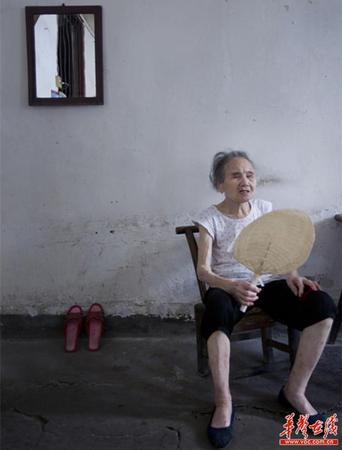 　90歲的王仲蓮如今已患有間歇性的老年癡呆，時而清醒、時而糊涂。圖為王仲蓮老人靜坐在屋內(nèi)，搖著蒲扇。