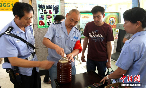 資料圖：7月29日，公安民警和安保人員正在克拉瑪依客運(yùn)站進(jìn)站口嚴(yán)查進(jìn)站旅客行李和違禁物品。 周建玲 攝