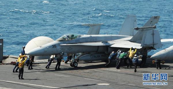 美軍開始對伊拉克極端組織發(fā)動空襲這張美國海軍8月8日提供的照片顯示，在海灣地區(qū)執(zhí)行任務(wù)的“喬治·H·W·布什”號航空母艦上，地勤人員指揮一架F A-18C大黃蜂戰(zhàn)斗機。新華社發(fā)