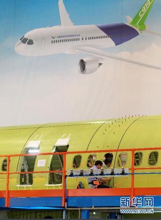 　 9月19日，技術(shù)人員對接C919首架機的機體。當(dāng)日，C919國產(chǎn)大型客機首架機在中國商飛公司新落成的總裝制造中心正式開始機體對接，這標(biāo)志著C919大型客機研制項目全面進入結(jié)構(gòu)總裝攻堅階段。項目力爭年底完成首架機機體結(jié)構(gòu)對接，2015年底實現(xiàn)首飛。新華社記者丁汀 攝
