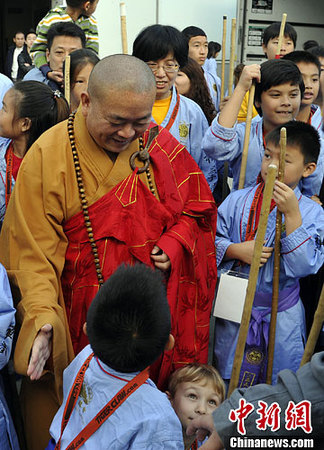 圖為少林寺釋永信方丈與參加武術(shù)交流的兒童們交談。中新社發(fā) 毛建軍 攝