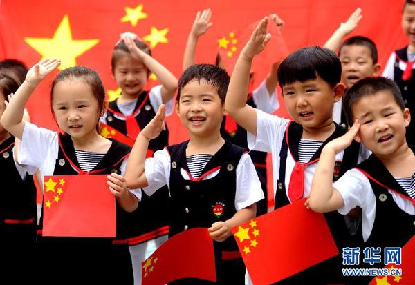 9月28日，安徽淮南市直機(jī)關(guān)幼兒園的小朋友在國(guó)旗前唱《國(guó)歌》，慶祝祖國(guó)65周歲生日。新華社發(fā)（陳彬 攝）
