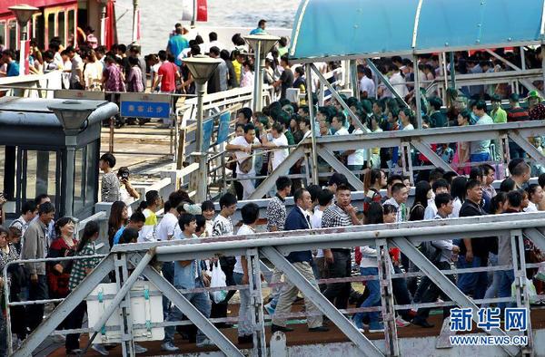10月1日，游客在上海外灘排隊(duì)乘坐觀光游輪。當(dāng)日是國慶長假第一天，全國各地旅游景點(diǎn)游人如織。 新華社記者 丁汀 攝