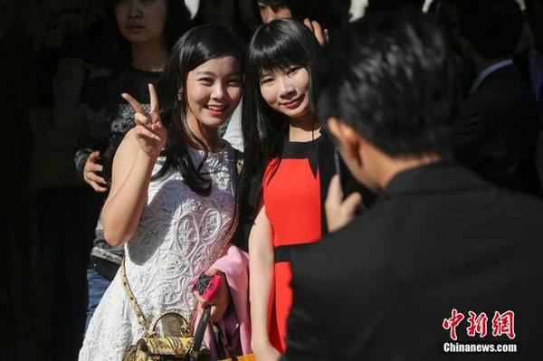 學(xué)生們?cè)诔扇硕Y上合影留念。