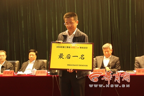 10月23日，渭南市召開的2014年縣區(qū)的政績考核會議上，有6個縣市區(qū)因為“較差”也上臺“領(lǐng)獎”，他們領(lǐng)到的是一個“最后一名”。圖為韓城市因為在財稅工作方面考核排名較后，獲取了一個黃牌。