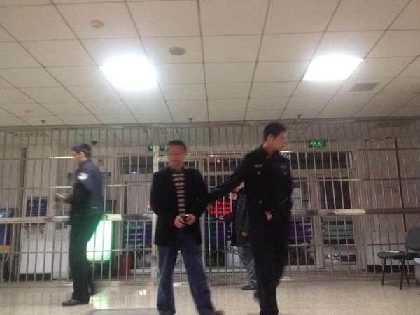 圖為房東（中）被警察帶回警局。