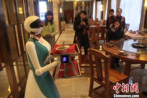 圖為機(jī)器人服務(wù)員正在為客人服務(wù)?！〈麒础z