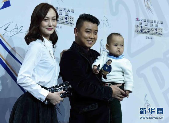 2月1日，前乒乓球國手王皓（中）抱著兒子小樂天與妻子閆博雅在頒獎典禮紅毯儀式上合影。當(dāng)日，“2014CCTV體壇風(fēng)云人物年度評選”頒獎典禮在京舉行。 新華社記者公磊攝