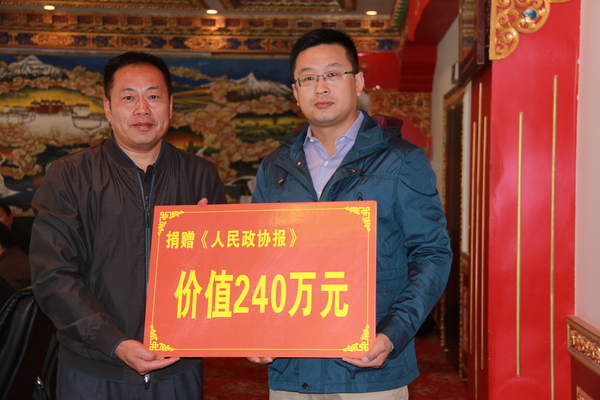 人民政協(xié)報(bào)社副社長王相偉（右）向西藏自治區(qū)政協(xié)副秘書長孫冬遞交捐贈牌匾2。