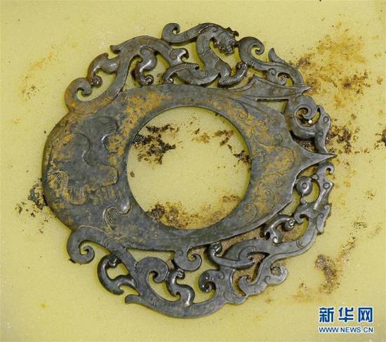 這是?；韬钅惯z址出土的雕有龍、鳳、虎圖案的玉佩（12月7日攝）