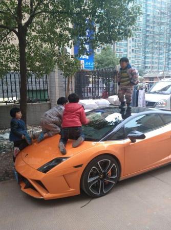 圖為2014年在網(wǎng)上流傳的蘭博基尼被虐照。這輛蘭博基尼停在路邊,一個“熊孩子”站在車頂,引擎蓋上也趴著兩個。這是一輛 2011 款的 Gallardo,車已停產(chǎn),售價在400萬左右。
