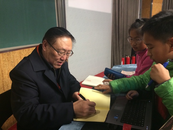 在三月二十二日北京中關(guān)村第一小學(xué)的讀書活動(dòng)上，著名作家高洪波委員給小學(xué)生簽名