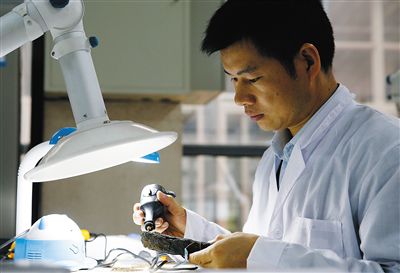 省博文保人員在對(duì)一件鐵器進(jìn)行除銹處理。省博文保人員采集浸泡華光礁I號(hào)船板的離子水進(jìn)行化學(xué)分析。