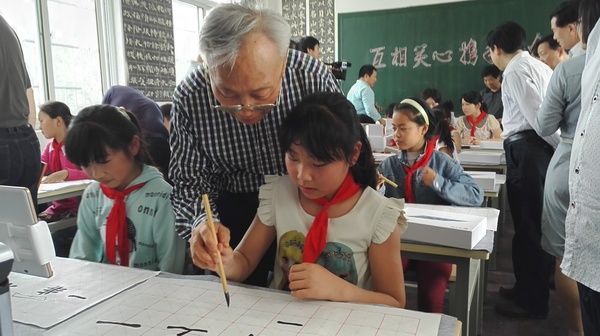 政協(xié)委員“手把手”給孩子們進行書法指導(dǎo)。