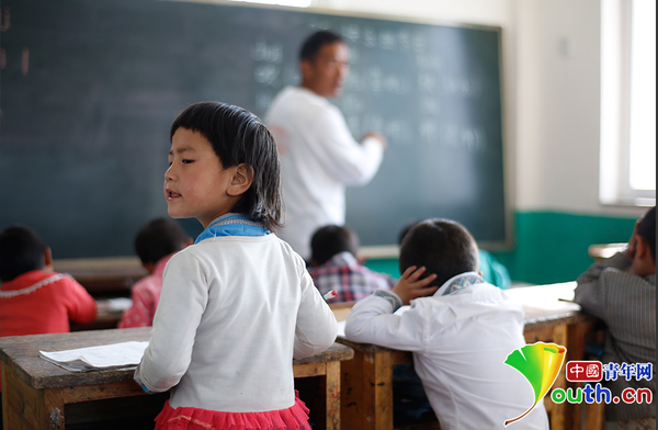 　6歲的藏族女孩黃娜姆措站著聽黃老師講課。黃三英的課堂上氛圍很活躍，孩子們跟黃老師一起，又學(xué)習(xí)、又玩耍。中國青年網(wǎng)記者 張炎良 攝