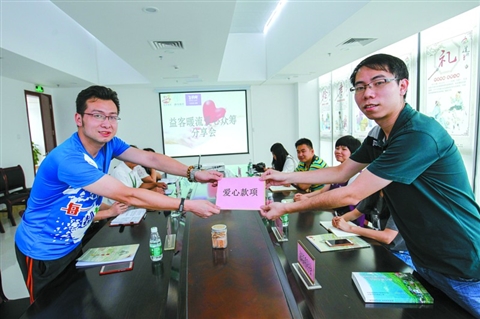 　　5月25日，益客暖流愛心眾籌分享會在高明好人工作室開啟。愛心商家代表(右)向公益聯(lián)盟單位代表獻上愛心款項。