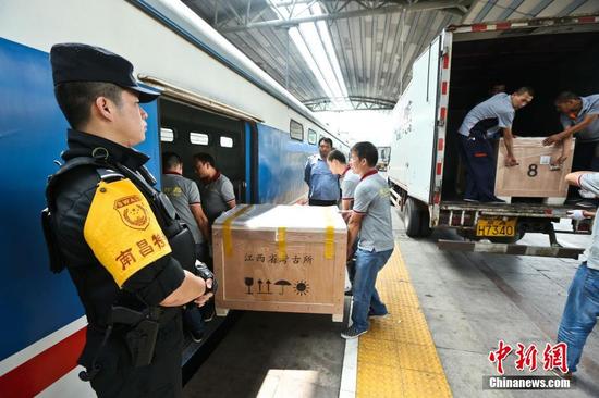 圖為6月29日，在北京站，文物保護人員將?；韬钗奈锇徇\上列車。 張學(xué)東 攝