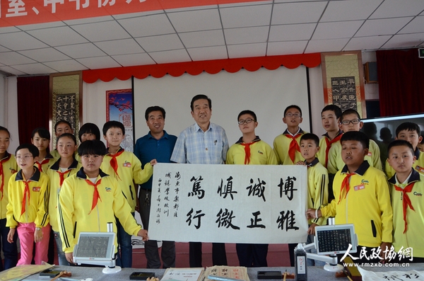 圖片說明：政協(xié)委員與學(xué)生展示創(chuàng)作的書法作品。