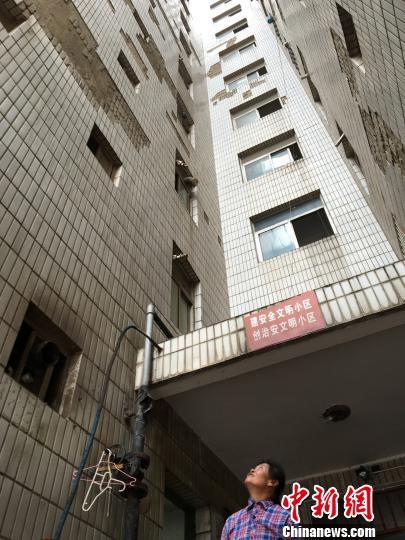 圖為白馬小區(qū)高層樓道口上方，墻磚脫落嚴(yán)重?！】姵?攝
