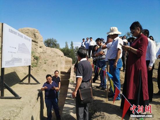 圖為專家現(xiàn)場講解北庭故城南門西側(cè)城墻文物挖掘情況。中新社記者 王小軍 攝