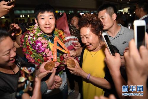 9月20日，接機(jī)民眾與里約殘奧會(huì)男子乒乓球冠軍葛楊（左二）合影。當(dāng)日，里約殘奧會(huì)中國(guó)代表團(tuán)抵達(dá)北京首都國(guó)際機(jī)場(chǎng)，受到接機(jī)民眾的熱烈歡迎。 新華社記者賀長(zhǎng)山攝 圖片來源：新華網(wǎng)