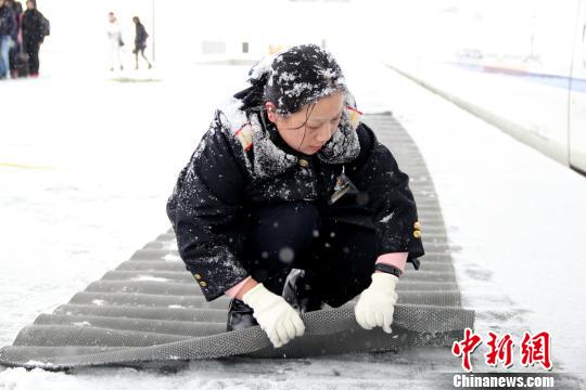 圖為鐵路工作人員在站臺上鋪設(shè)防滑墊?！∏劓z