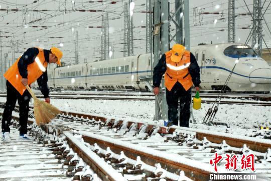 圖為鐵路工作人員進(jìn)行鐵軌防凍除雪工作?！⊥跏锾臁z