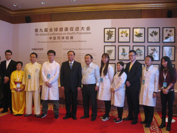 五、王國強與中醫(yī)藥體驗展的工作人員留影。 人民政協(xié)網(wǎng)記者  張春莉  攝影