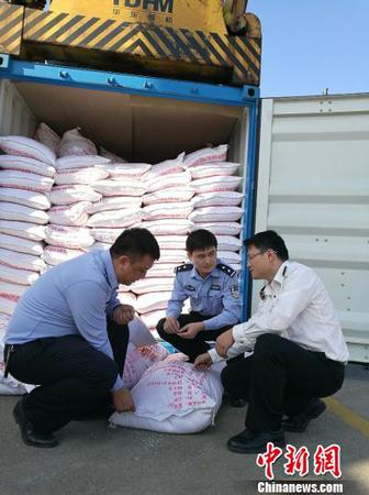圖為海關(guān)關(guān)員、緝私警察查看涉嫌走私大米 周磊 攝