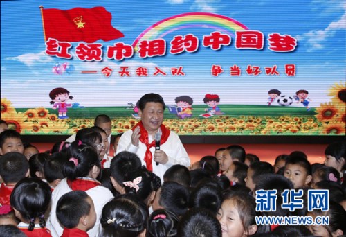 2014年5月30日上午，習(xí)近平來(lái)到北京市海淀區(qū)民族小學(xué)，參加慶?！傲弧眹?guó)際兒童節(jié)活動(dòng)。這是習(xí)近平在參加少先隊(duì)入隊(duì)儀式時(shí)，向少先隊(duì)員們致以節(jié)日問(wèn)候。新華社記者 鞠鵬 攝