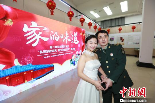 軍人姚振峰和王曉雪在“家的味道”展覽場地拍攝婚紗照?！逃?攝