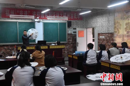 嚴磊在課堂上講授如何進行油紙傘包頂，17名學生紛紛抬起頭聽講?！蚊?攝