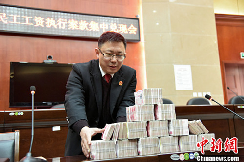北川法院為農(nóng)民工討薪 145萬工資集中兌付。圖為執(zhí)法人員正在清點成捆的鈔票。<a target='_blank' href='http://www.chinanews.com/'>中新社</a>記者 楊勇 攝