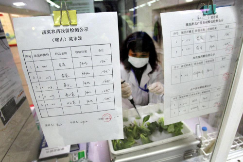 楊浦區(qū)鞍山菜場(chǎng)“快檢室”內(nèi)，一位檢測(cè)員正在對(duì)蔬菜樣品進(jìn)行農(nóng)藥殘留指標(biāo)試紙檢測(cè)，相關(guān)檢測(cè)結(jié)果每天公示。