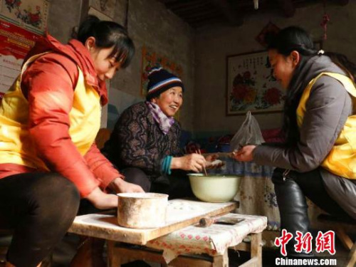 資料圖：除夕，巨鹿縣居家養(yǎng)老服務(wù)中心工作人員王勝晨、陳云彩和失獨老人張會群一起包餃子?！⊥醣麖?攝