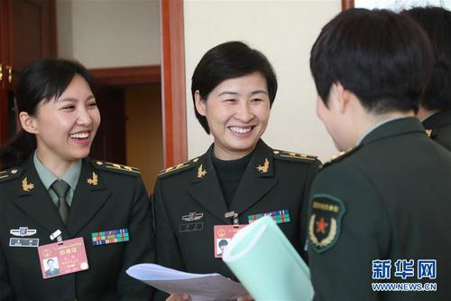 3月7日，全國(guó)人大代表劉洋（左二）等在解放軍代表團(tuán)小組會(huì)議間隙交流。在兩會(huì)會(huì)場(chǎng)內(nèi)外，女代表、女委員、女工作人員、女記者在工作中盡職盡責(zé)，展現(xiàn)著自己的風(fēng)采。 新華社記者 李剛 攝