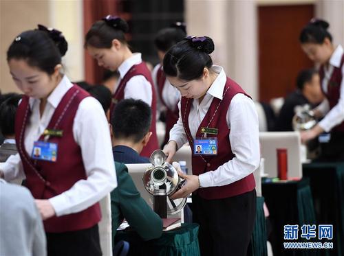 3月6日，北京華北賓館的女服務(wù)員在民盟、無(wú)黨派人士界委員聯(lián)組會(huì)上倒水。在兩會(huì)會(huì)場(chǎng)內(nèi)外，女代表、女委員、女工作人員、女記者在工作中盡職盡責(zé)，展現(xiàn)著自己的風(fēng)采。 新華社記者張鐸攝
