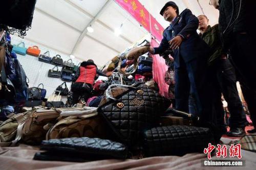 資料圖 工商人員查出涉嫌出售假名牌包的攤位，將假貨沒(méi)收。 徐曉帆 攝 圖片來(lái)源：CFP視覺(jué)中國(guó)
