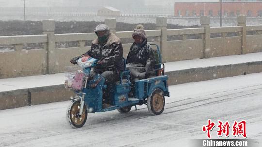 圖為降雪導(dǎo)致路面結(jié)冰濕滑?！＄娦?攝