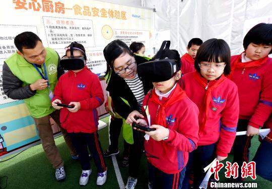 活動(dòng)現(xiàn)場(chǎng)，小學(xué)生通過(guò)VR(虛擬現(xiàn)實(shí))技術(shù)設(shè)備模擬廚房場(chǎng)景，在互動(dòng)中學(xué)習(xí)生熟分開(kāi)，菜品搭配與油鹽使用的廚房食品安全知識(shí)?！∮浾邉⒖筛?攝