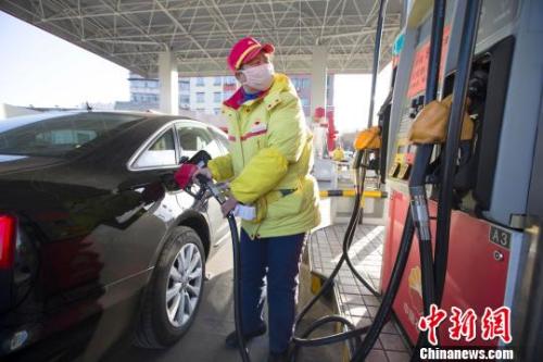 資料圖：山西太原，加油站工作人員正在給車輛加油。張?jiān)?攝