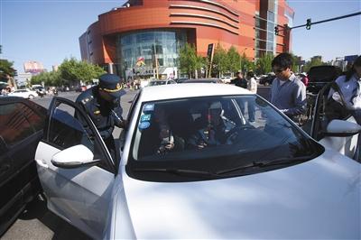 4月24日，交通執(zhí)法人員在朝陽大悅城附近，對一輛非法營運(yùn)車輛進(jìn)行查處。新京報記者 王貴彬 攝