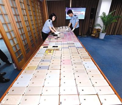北京警方破獲特大盜銷(xiāo)手機(jī)團(tuán)伙，起獲的525部被盜手機(jī)鋪滿(mǎn)了一張大桌子，其中大多是蘋(píng)果手機(jī)。	警方供圖