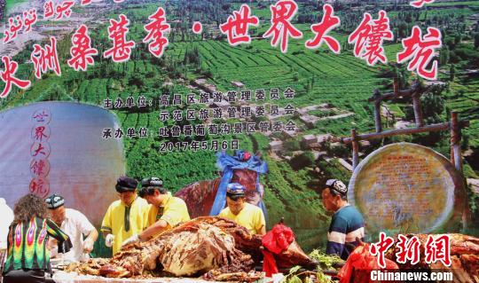 5月6日下午，吐魯番高昌區(qū)舉辦“火洲桑葚季?世紀(jì)大馕坑”活動，烤全牛肉免費(fèi)分享游客?！∈酚窠z