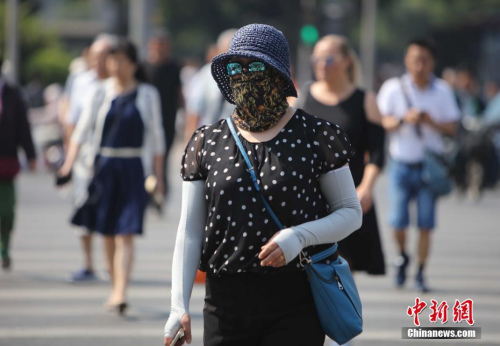 資料圖：5月17日，北京街頭的民眾防曬出行。當日北京市氣象臺發(fā)布今年首個高溫黃色預警。<a target='_blank' href='http://www.chinanews.com/'>中新社</a>記者 楊可佳 攝