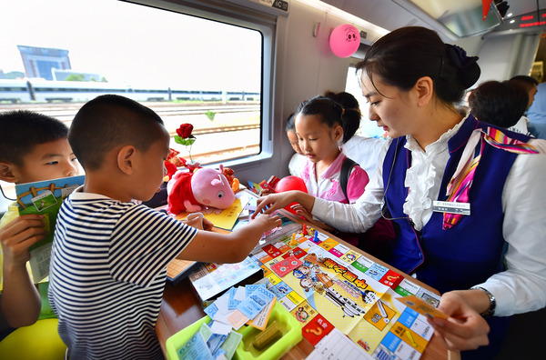 北京鐵路局天津客運(yùn)段值乘的廈門北至北京南G324次列車乘務(wù)員與兒童旅客互動(dòng)做游戲。